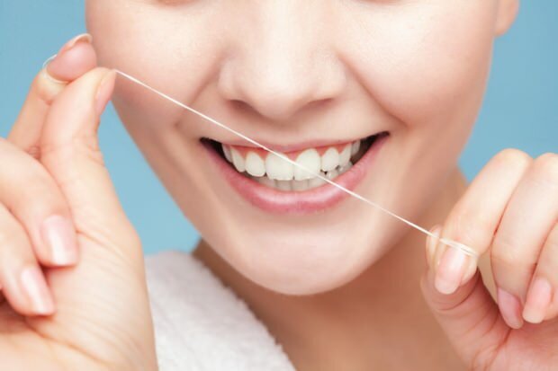 Det anbefales at bruge tandtråd for at fjerne rester mellem tænderne.