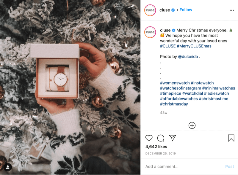 instagram post fra @cluse viser et billede af en snefnug-sweater model, der holder et ur foran et snedækket træ af @dulceida med hashtags #cluse og #meryclusemas