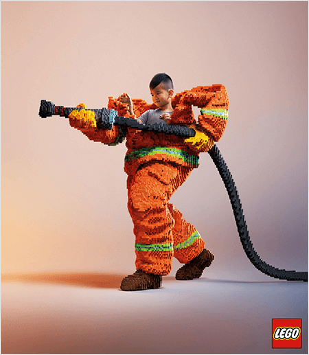 Dette er et foto fra en LEGO-annonce, der viser en ung asiatisk dreng inde i en brandmanduniform lavet af LEGO'er. Uniformen er orange med en neongrøn stribe omkring ærmerne og bukserne. Brandmanden står med en fod tilbage og holder en brandslange, også lavet af legoer. Drengens hoved ser ud af toppen af ​​uniformen, som er meget større end han er og stopper omkring skuldrene. Billedet blev taget på en almindelig neutral baggrund. LEGO-logoet vises i en rød boks nederst til højre. Talia Wolf siger, at LEGO er et godt eksempel på et brand, der bruger følelser i reklamer.