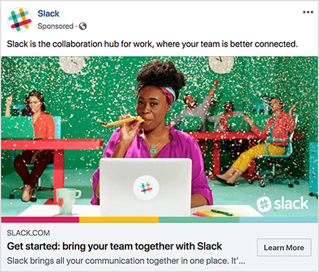 Dette er et screenshot af en Facebook-annonce til Slack. Annonceteksten siger "Slack er samarbejdshub for arbejde, hvor dit team er bedre forbundet." På annoncebilledet sidder en sort kvinde ved et skrivebord med en grå bærbar computer. Hendes hår er kort og holdes tilbage med et farverigt pandebånd. Hun har på sig en fuschia-bluse og en turkis halskæde, og hun blæser gennem en gul støjemaskine. I baggrunden sidder andre mennesker ved skriveborde og har farverigt tøj på. Kontoret er malet lysegrønt, og konfetti falder ned fra loftet. Talia Wolf anbefaler at bruge fotos som denne, der viser rå følelser, i dine annoncer.
