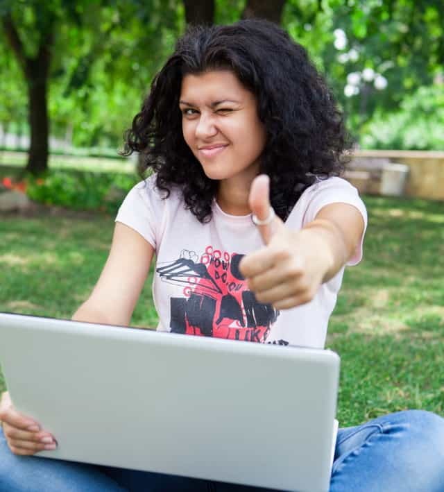 Pige på bærbar computer i Park