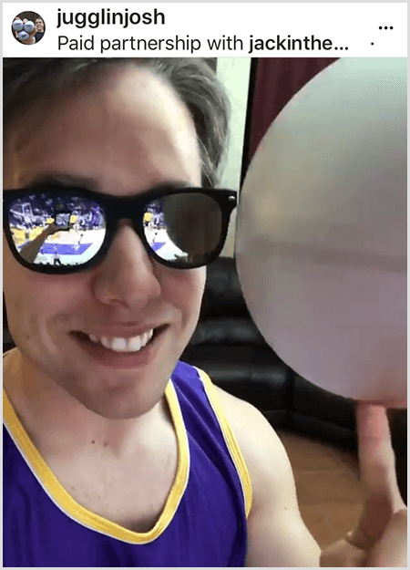 Josh Horton sender et foto til en kampagne med Jack in the Box og LA Lakers. Josh bærer spejlede solbriller og en Lakers-trøje og smiler til kameraet mens han snurrer en bold.